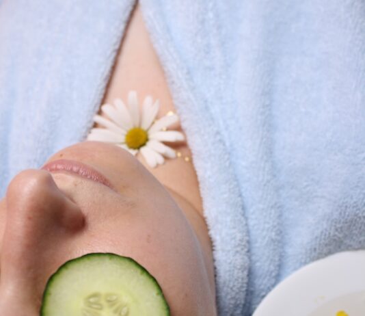 맑고 건강한 피부를 위한 습관과 관리 방법 woman wearing blue robe lying with cucumber on eye