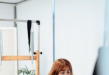 필라테스로 건강관리 하는 법 a woman on a rowing machine in a gym