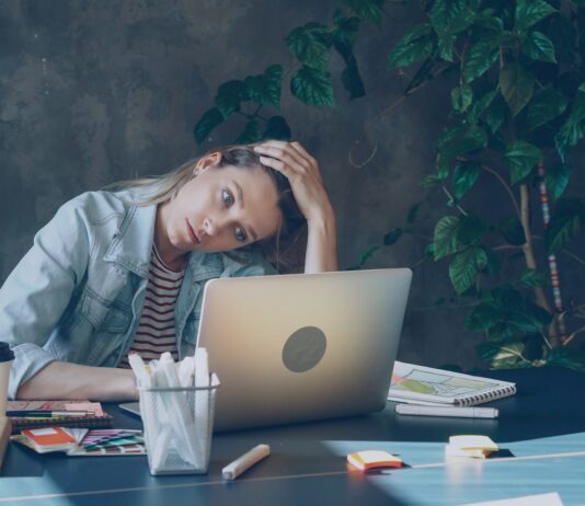 의도적인 로그아웃: 번아웃 시대, 나를 지키는 디지털 디톡스 A woman appears stressed while working on laptop.