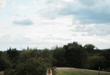 마음 건강도 챙기는 ‘마음 챙김 산책’, 일상 속 작지만 큰 변화 A person walks on a path in a grassy landscape.