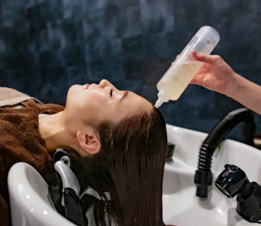 건강한 두피가 아름다운 머릿결을 만든다…일상 속 ‘헤어 루틴’ 실천법 주목 a woman getting her hair washed with a hair dryer