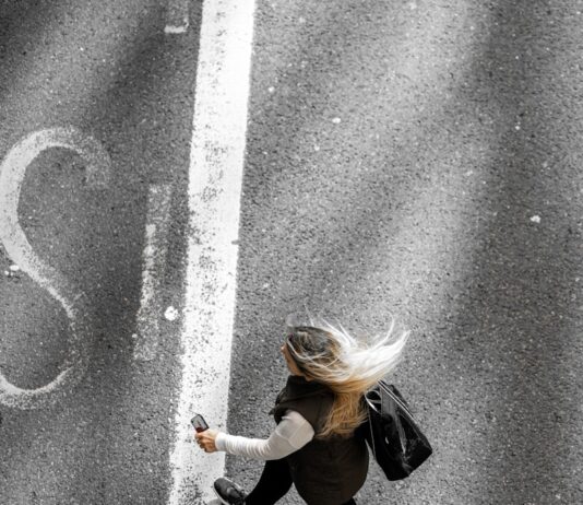 멈추지 않는 피로감, 만성피로 극복을 위한 작은 변화가 해답 woman in black jacket and black pants walking on gray asphalt road during daytime
