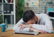 만성피로, ‘작은 변화’로 이겨내자…실생활 실천 루틴 제안 a man sitting at a desk with his head in his hands