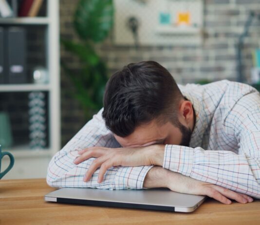 만성피로, ‘작은 변화’로 이겨내자…실생활 실천 루틴 제안 a man sitting at a desk with his head in his hands