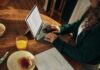 디지털 디톡스, 건강한 일상을 위한 첫걸음 Woman typing on laptop at wooden table with breakfast.