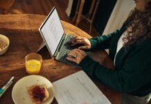 디지털 디톡스, 건강한 일상을 위한 첫걸음 Woman typing on laptop at wooden table with breakfast.