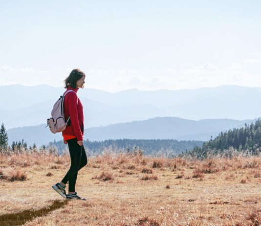 일상 속 걷기 루틴, 건강을 지키는 가장 손쉬운 습관 a man with a backpack walking across a dry grass covered field